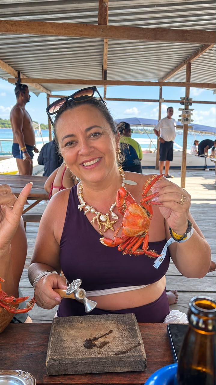 Cliente sorrindo com um caranguejo em um restaurante à beira-mar